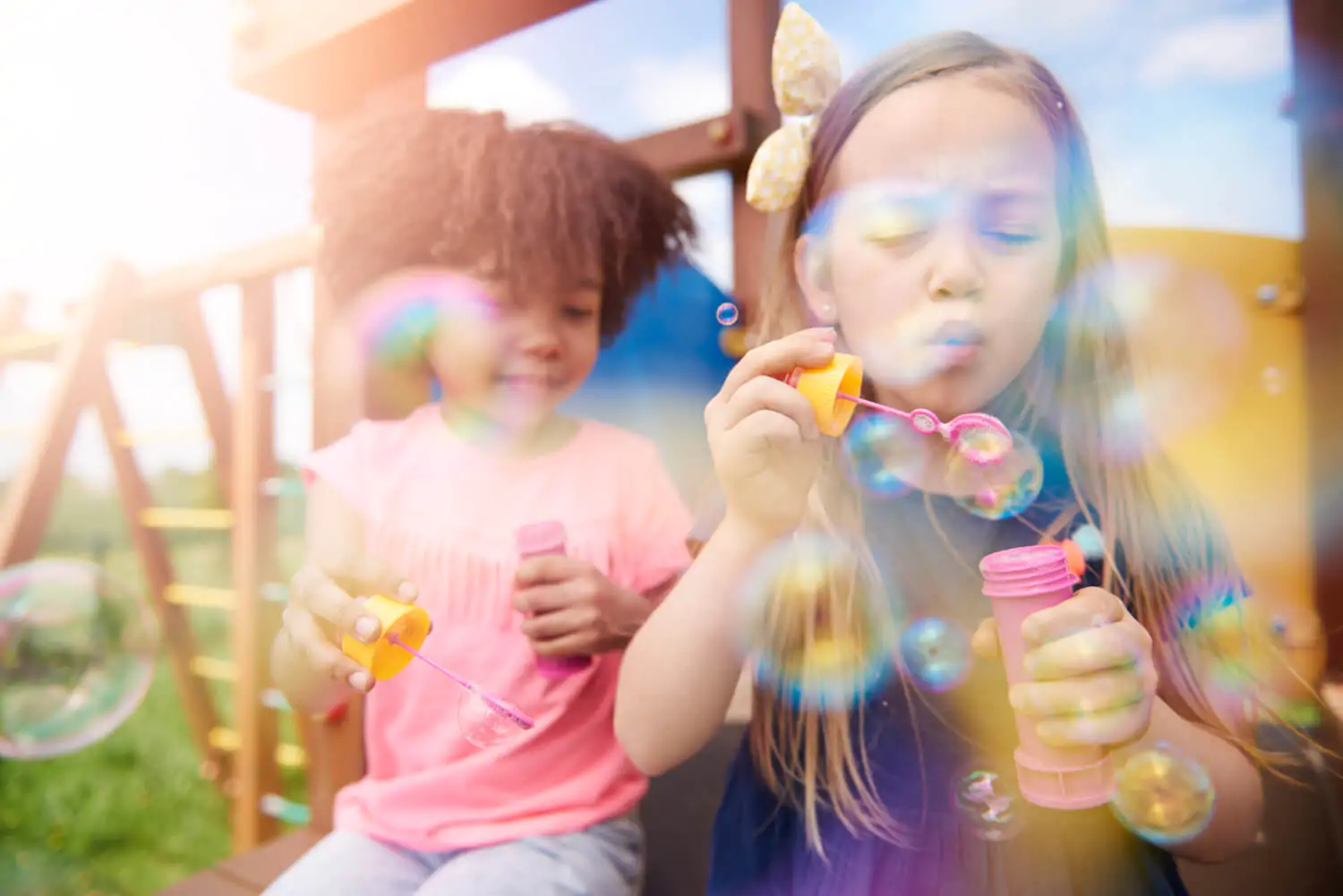 Crianças brincando ao ar livre com bolhas de sabão em momento de diversão e desenvolvimento infantil