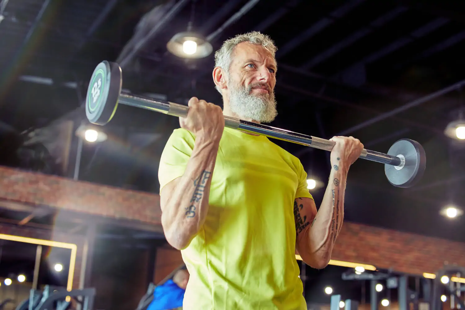 Homem realizando treino de força com barra para fortalecer músculos, ossos e articulações.